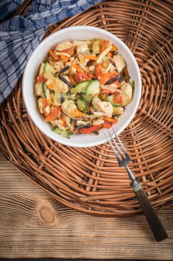 Kızarmış tavuk parçaları ile beyaz bir kase sebze. Üstten Görünüm.