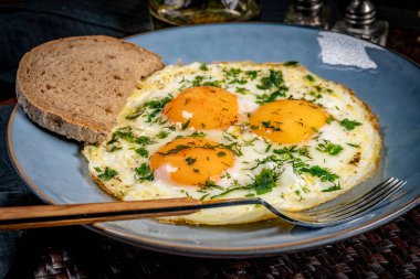 Tabakta bir dilim ekmekle sahanda yumurta. Sığ alan derinliği.