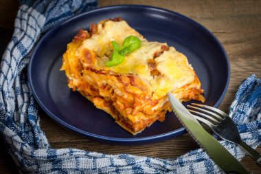 Kırmızı şarap ile lezzetli sıcak lazanya parçası. Küçük alan derinliği.