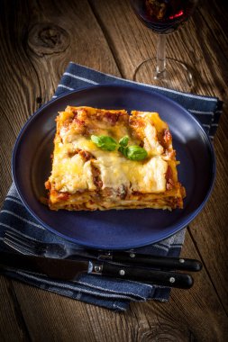 Kırmızı şarap ile lezzetli sıcak lazanya parçası. Küçük alan derinliği.