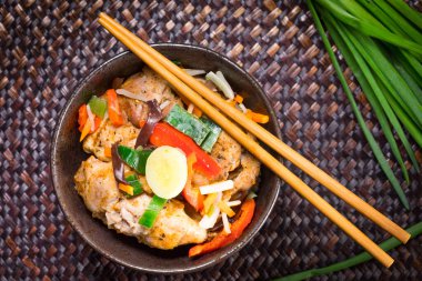 Pirinç ve sebzeyle servis edilen kızarmış tavuk parçaları. Üst görünüm.