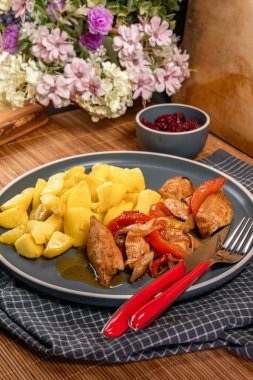 Haşlanmış tavuk parçaları, sebze ve patates ile servis edilir..