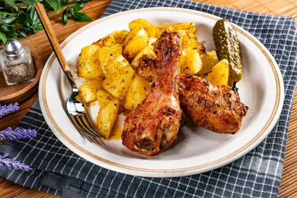 Fırında tavuk budu ve patates. Sığ alan derinliği.