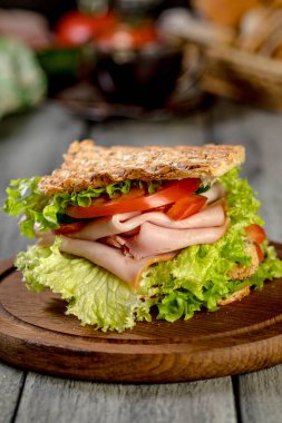 Sandviç ile jambon, salatalık, domates, marul, dolum üç dilim kızarmış ekmek arasında iki kat ile.