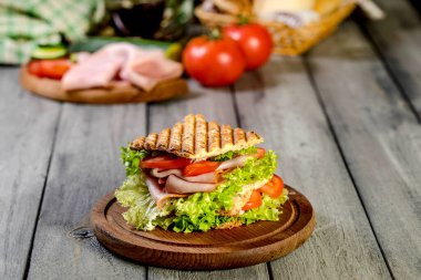 Sandviç ile jambon, salatalık, domates, marul, dolum üç dilim kızarmış ekmek arasında iki kat ile.