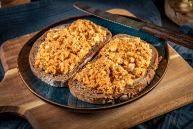 Yumurtalı ekmek dilimleri ve domatesli sprat ezmesi. Seçici odak.