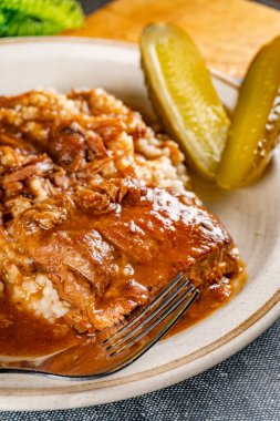 Baharat soslu haşlanmış domuz kaburgası arpa ve salatalık turşusu ile servis edilir. Seçici odak.