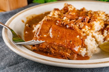 Baharat soslu haşlanmış domuz kaburgası arpa ve salatalık turşusu ile servis edilir. Seçici odak.