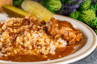 Baharat soslu haşlanmış domuz kaburgası arpa ve salatalık turşusu ile servis edilir. Seçici odak.