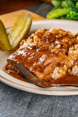 Baharat soslu haşlanmış domuz kaburgası arpa ve salatalık turşusu ile servis edilir. Seçici odak.