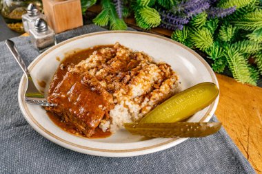 Baharat soslu haşlanmış domuz kaburgası arpa ve salatalık turşusu ile servis edilir. Seçici odak.