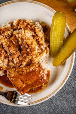 Baharat soslu haşlanmış domuz kaburgası arpa ve salatalık turşusu ile servis edilir. Seçici odak.