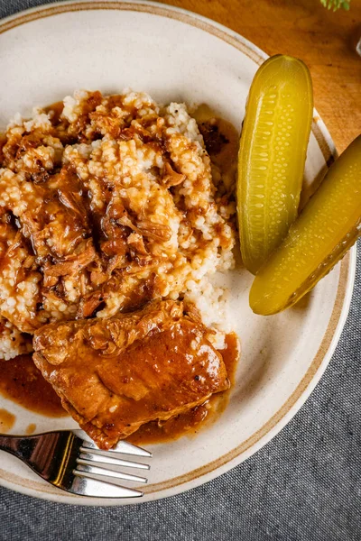 Baharat soslu haşlanmış domuz kaburgası arpa ve salatalık turşusu ile servis edilir. Seçici odak.