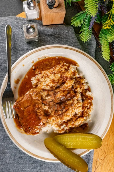 Baharat soslu haşlanmış domuz kaburgası arpa ve salatalık turşusu ile servis edilir. Seçici odak.