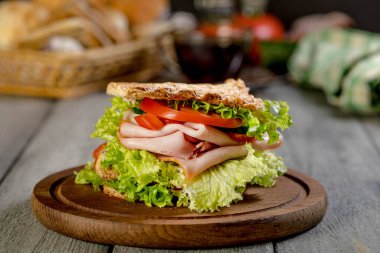 Sandviç ile jambon, salatalık, domates, marul, dolum üç dilim kızarmış ekmek arasında iki kat ile.