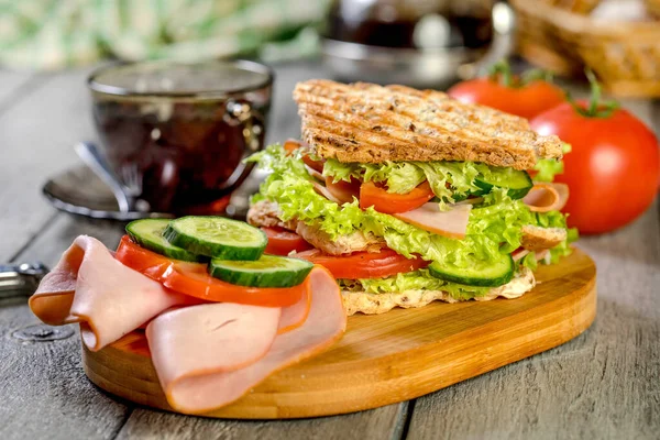 Sandviç ile jambon, salatalık, domates, marul, dolum üç dilim kızarmış ekmek arasında iki kat ile.