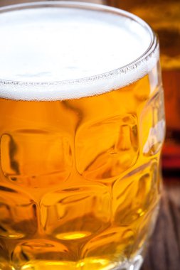 Bir bardak bira ahşap bir masa üzerinde.