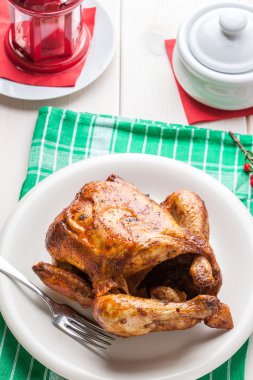 Beyaz plaka üzerinde pişmiş tavuk.