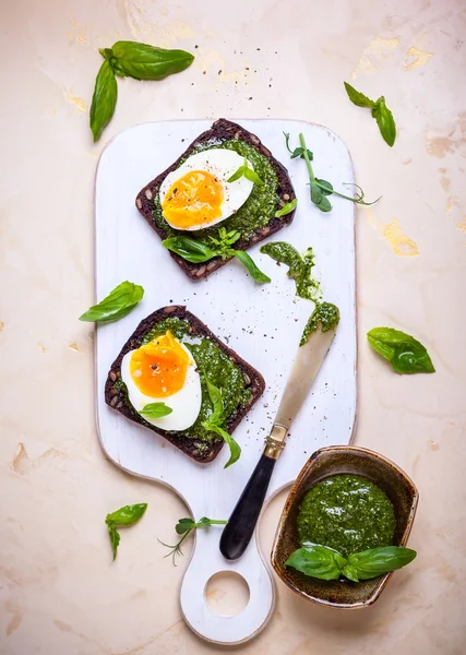 Boiled egg with pesto on toasts — Stock Photo, Image