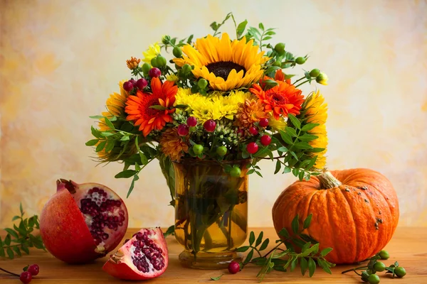 Herfst bloemen, granaatappel en pompoen — Stockfoto