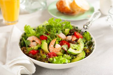 Karidesli taze yaz salatası, avokado ve ışık masasında domates kirazı. Sağlıklı beslenme kavramı.
