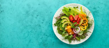 Lezzetli sağlıklı avokado salatası, domates, salatalık, biber, marul, beyaz tabakta mikroçerez. Temiz yemek, yemek kasesi. Üst görünüm.