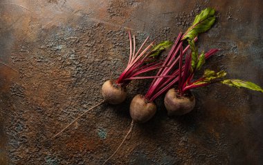 Arka planda yaprakları olan taze pancar kökü. Üst görünüm, alanı kopyala.