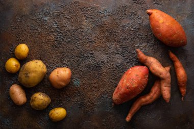 Dokulu arka planda farklı patatesler. Kök sebze hasadı.