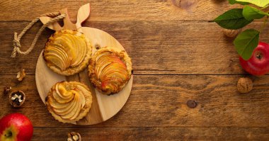 Tahta masada cevizli mini elmalı turtalar. Sonbahar kış yemeği için nefis bir tatlı..
