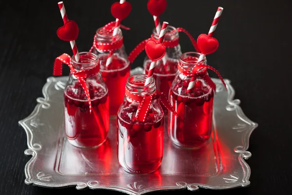 Small bottles with cranberry cocktail