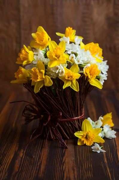 Narcisos en un jarrón de ramita —  Fotos de Stock