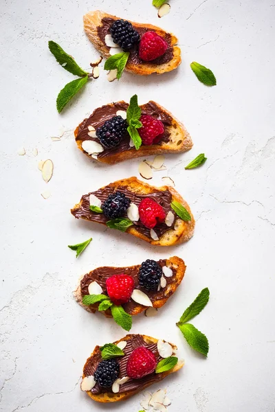 Berry bruschetta with chocolate nut butter — Stock Photo, Image