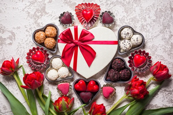 Trufas de chocolate e flores vermelhas — Fotografia de Stock