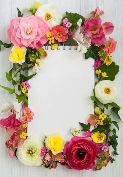 Tomt anteckningsblock och blommor — Stockfoto