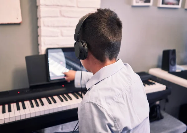 Child learning piano online lessons in quarantine . Coronavirus life style