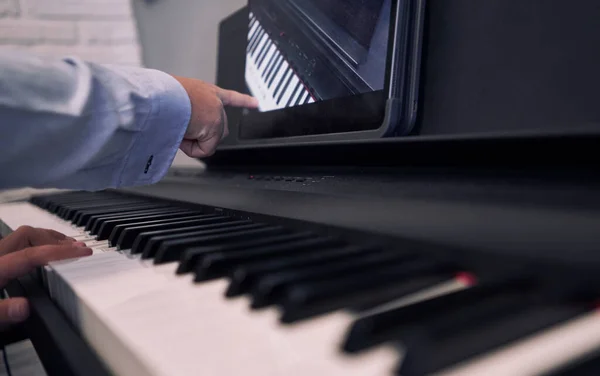 Child learning piano online lessons in quarantine . Coronavirus life style