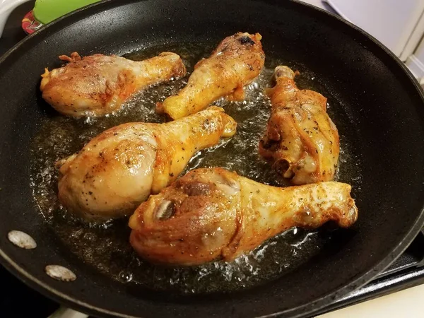 Chicken drumsticks boiling in hot oil in pan — Stock Photo, Image