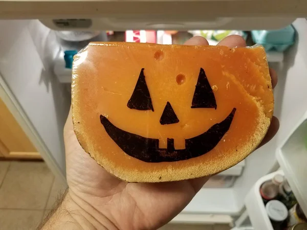 Queijo laranja com rosto de abóbora de Halloween e geladeira — Fotografia de Stock