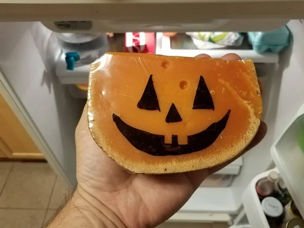 Orangenkäse mit Kürbisgesicht im Kühlschrank — Stockfoto