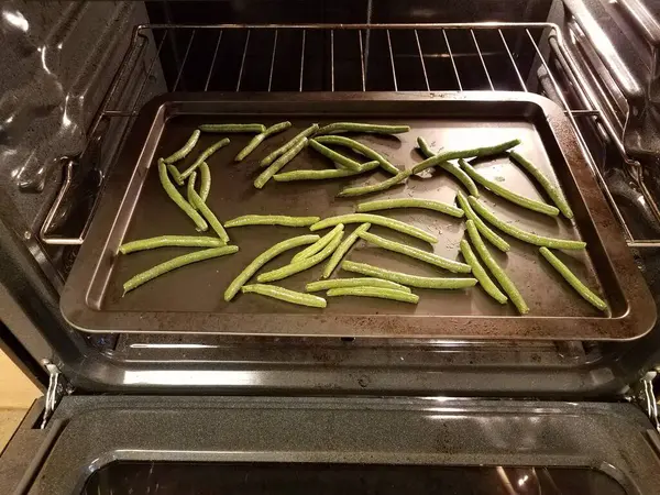 Feijão verde temperado na assadeira no forno — Fotografia de Stock