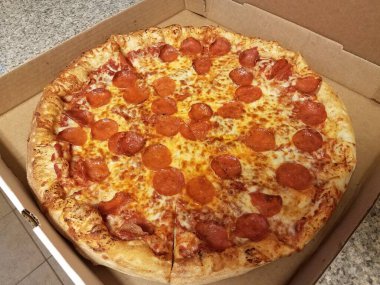 Biberli pizza tezgahın üstünde karton kutuda.