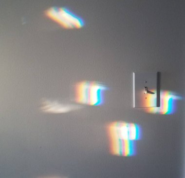 kırmızı, mavi ve gökkuşağı spektrum renkleri ışık anahtarıyla duvara yansıtılıyor