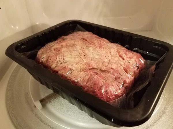 pulled pork meat in plastic bag in microwave