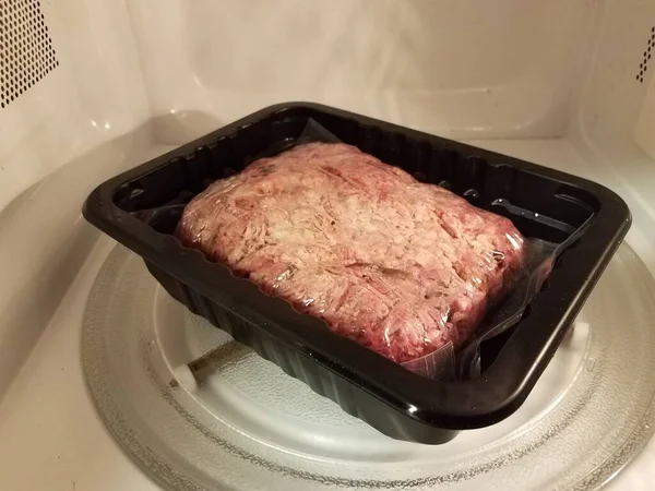 pulled pork meat in plastic bag in microwave