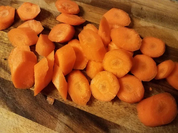 Zanahorias anaranjadas en rodajas en tabla de cortar madera — Foto de Stock