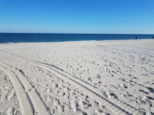 Tire tracks on sand on the beach or shore with water — Stock Photo, Image