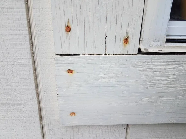 Chiodi arrugginiti in legno bianco sulla costruzione — Foto Stock