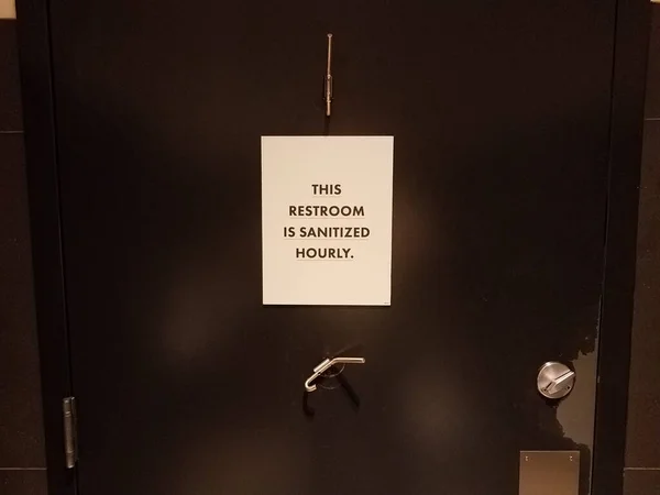 Toilettes est santized signe horaire sur la porte de la salle de bain — Photo