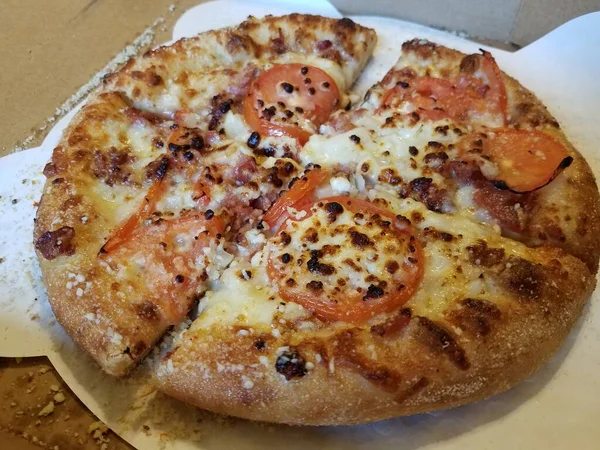 小さなピザにトマトとチーズが入っています — ストック写真