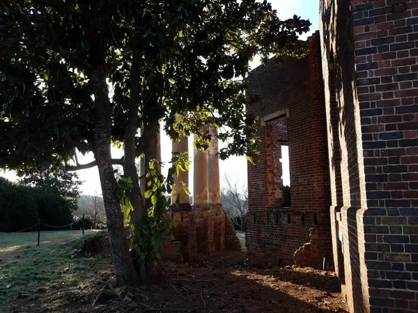 Edificio de ladrillo rojo ruinas y columnas y árboles — Foto de Stock